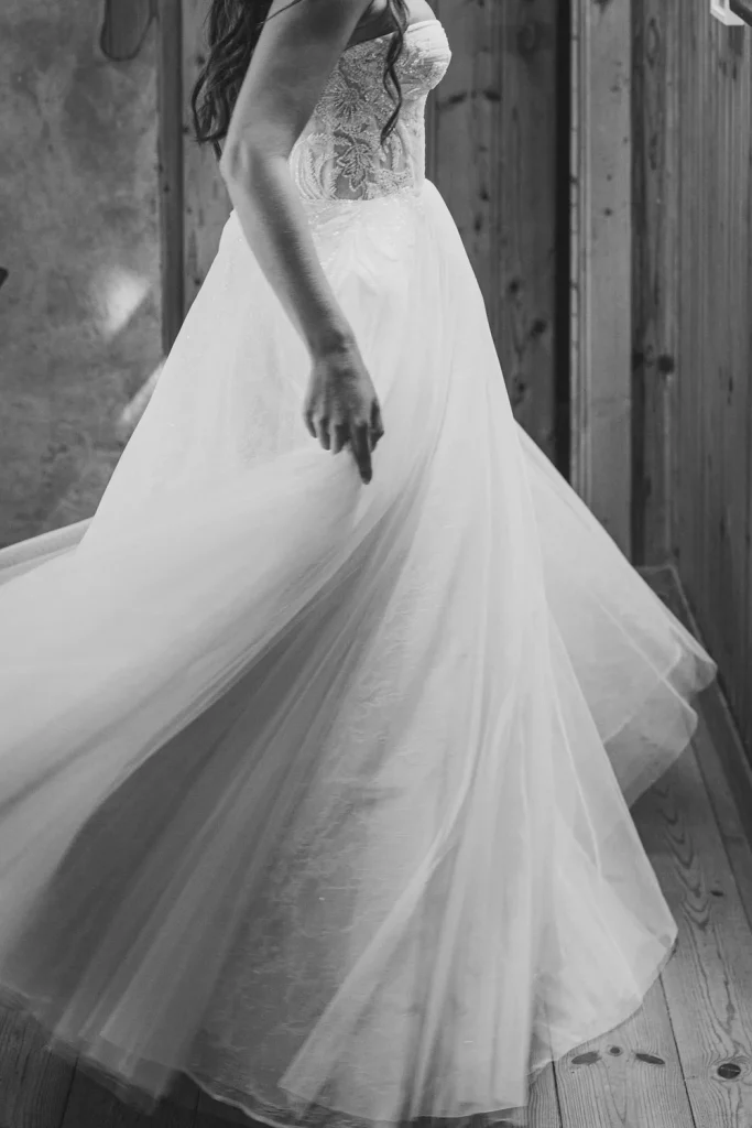 Black and white photo of the bride twirling in her wedding dress.