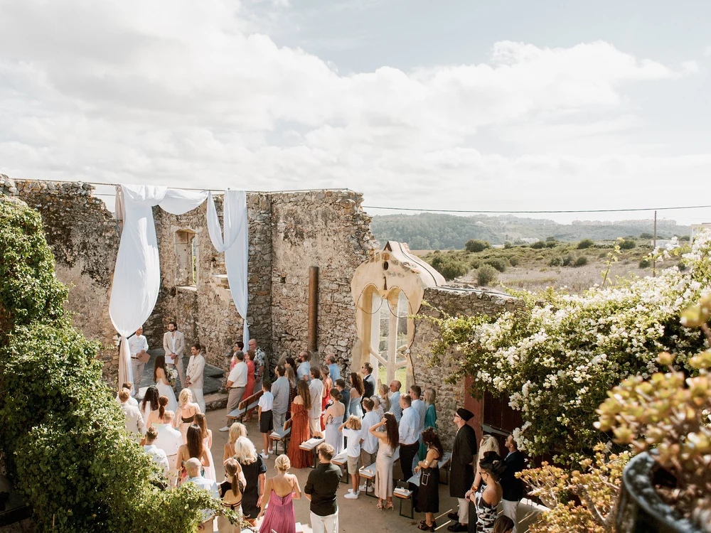 Aerial view of a wedding ceremony taking place in an ancient stone ruin at Casa Paço D'Ilhas, a wedding venue in Ericeira, Portugal